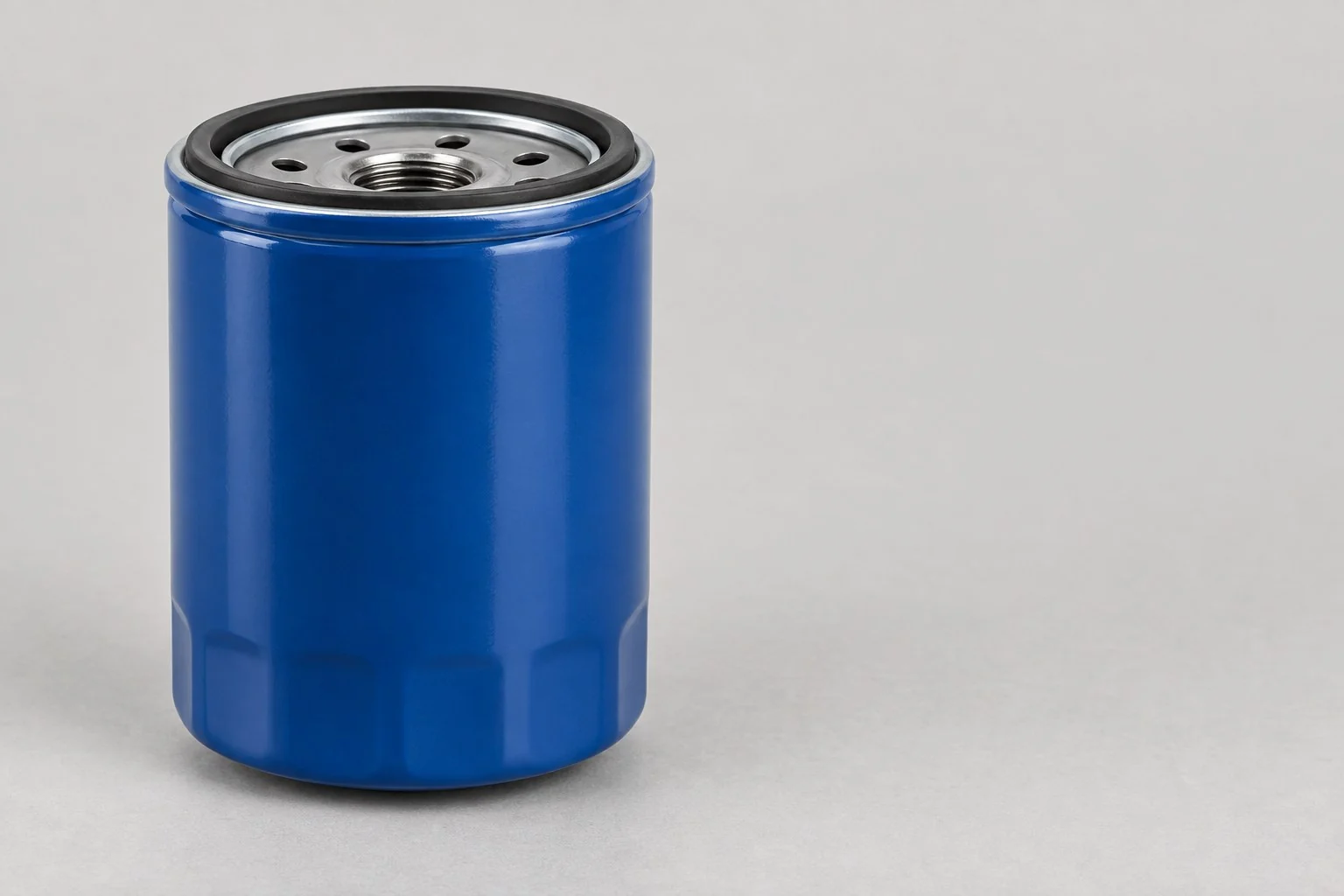 Blue spin-on oil filter with a black gasket and threaded centre, without annotations