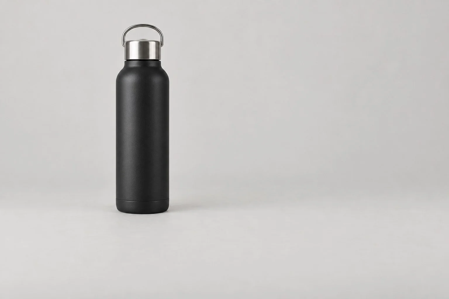 Matte black stainless steel water bottle with a steel screw cap and loop handle, without annotations