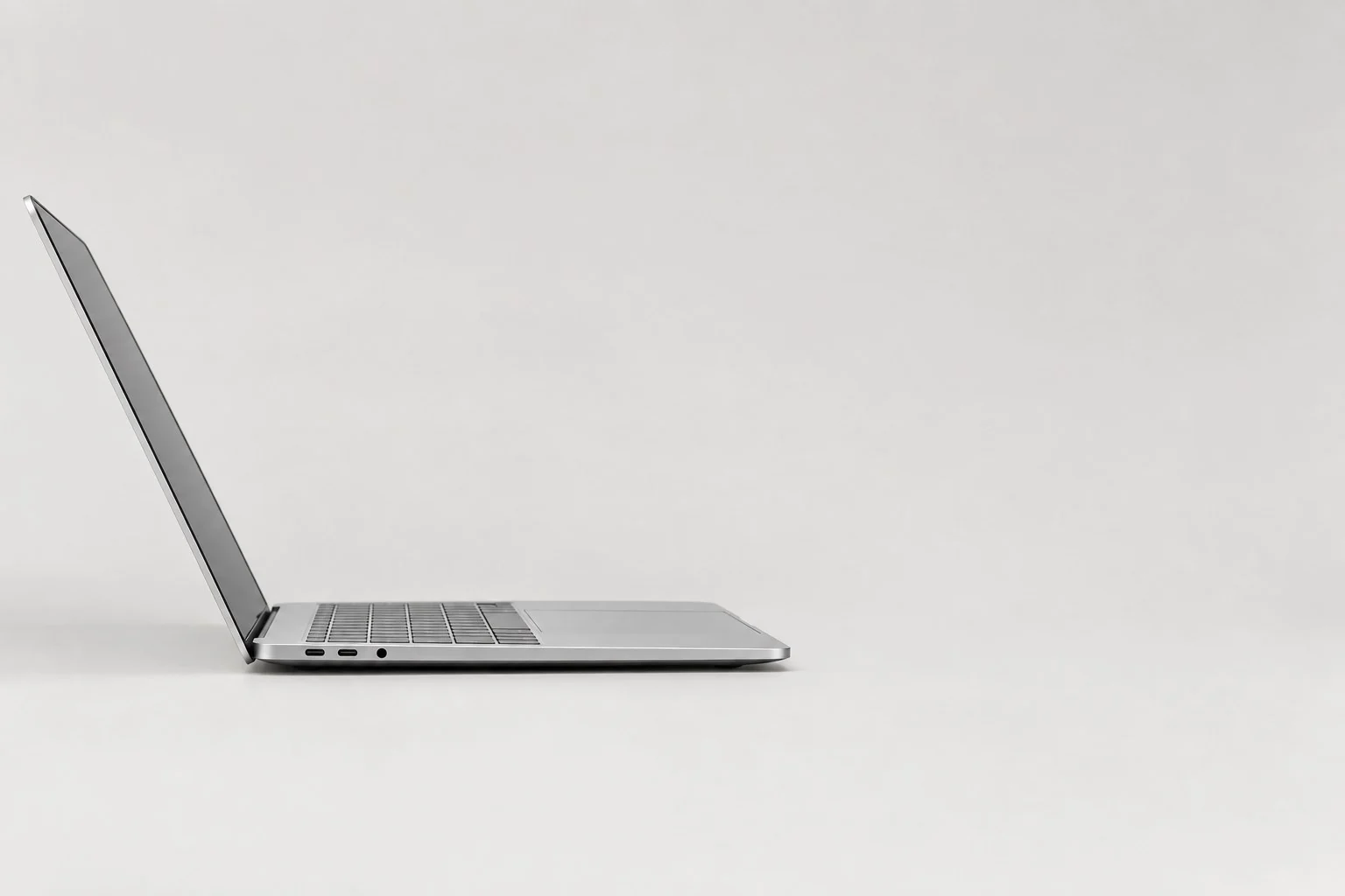 Laptop plateada abierta fotografiada de lado, sin anotaciones