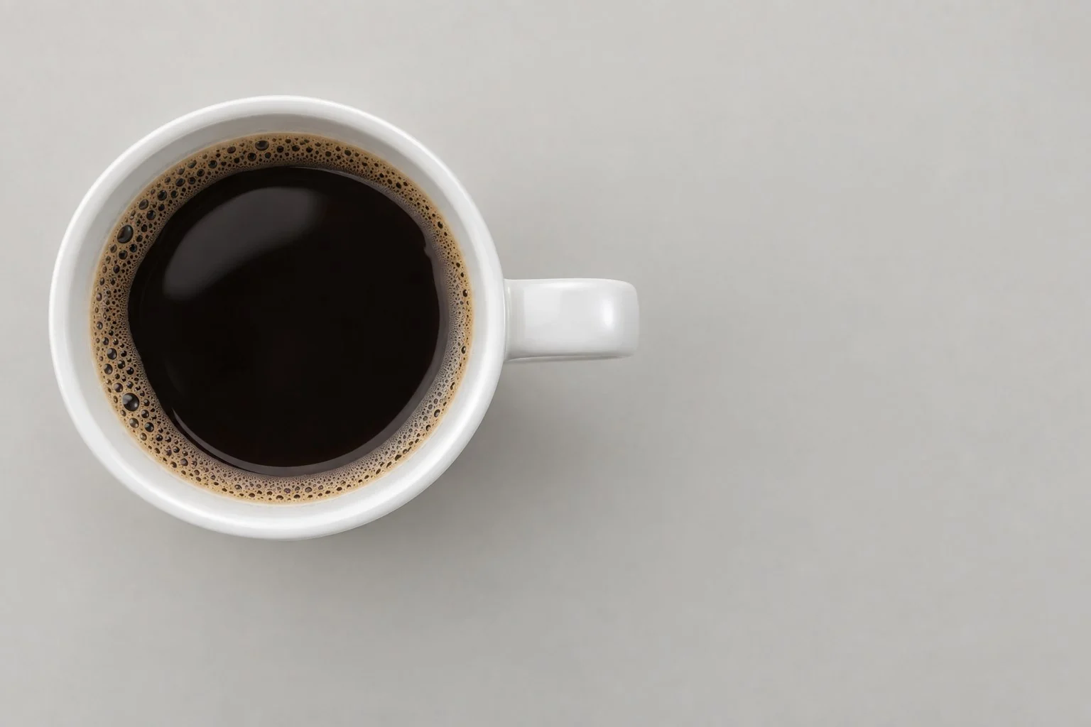แก้วมัคสีขาวใส่กาแฟดำ มุมมองจากด้านบน ไม่มีคำอธิบาย