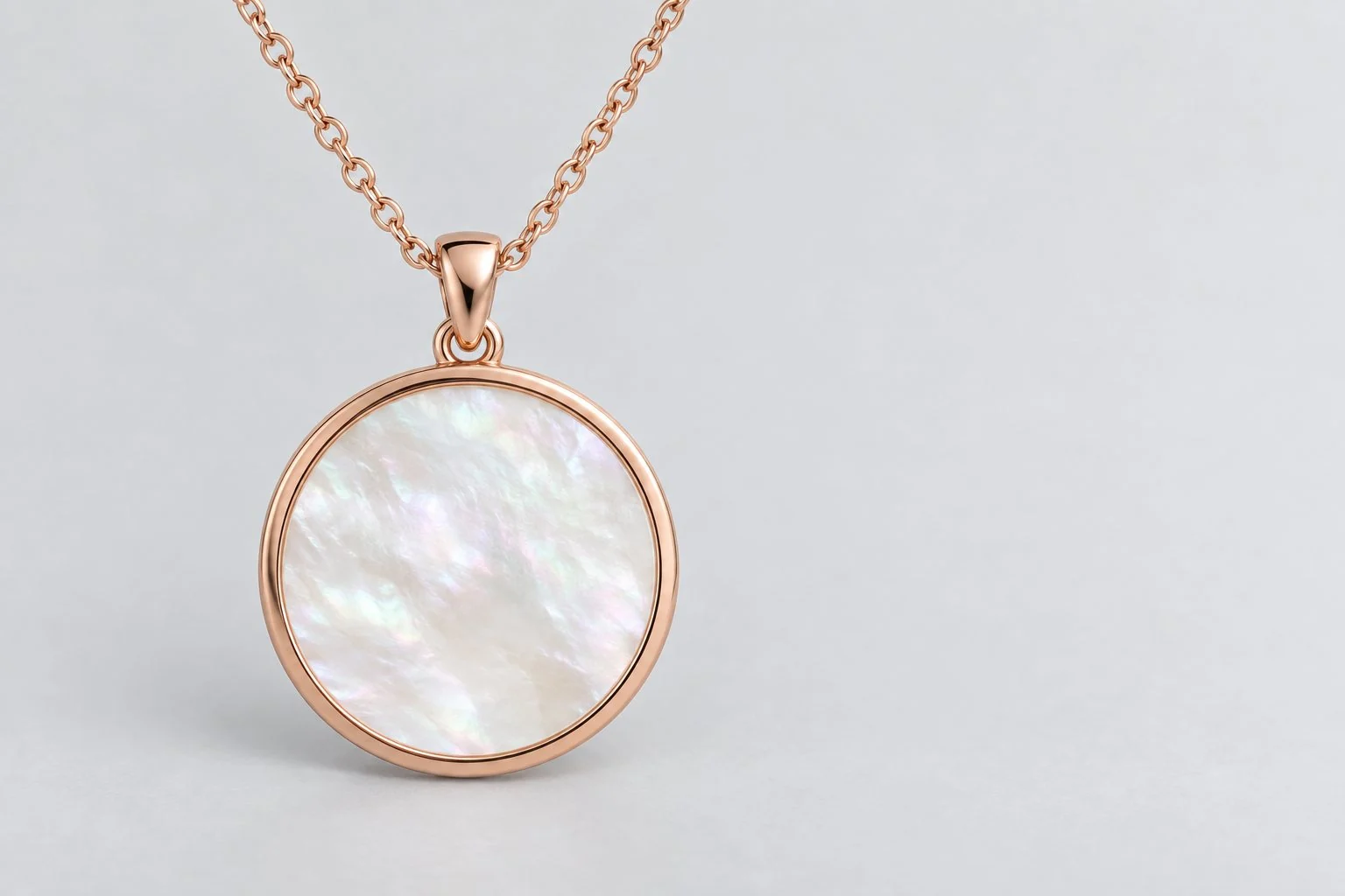 Round pendant necklace with a rose gold-tone frame and a pearly white face on a chain, without annotations