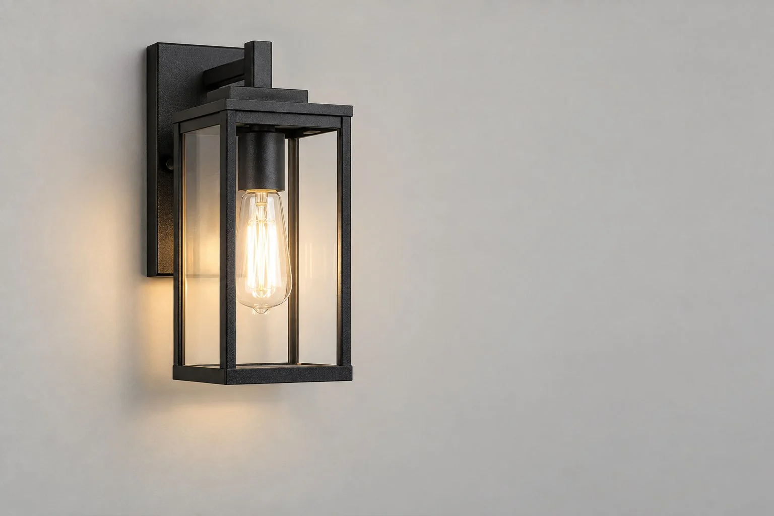 Schwarze Wandleuchte im Laternenstil mit klaren Glasscheiben und leuchtender Filament-Lampe, ohne Beschriftungen