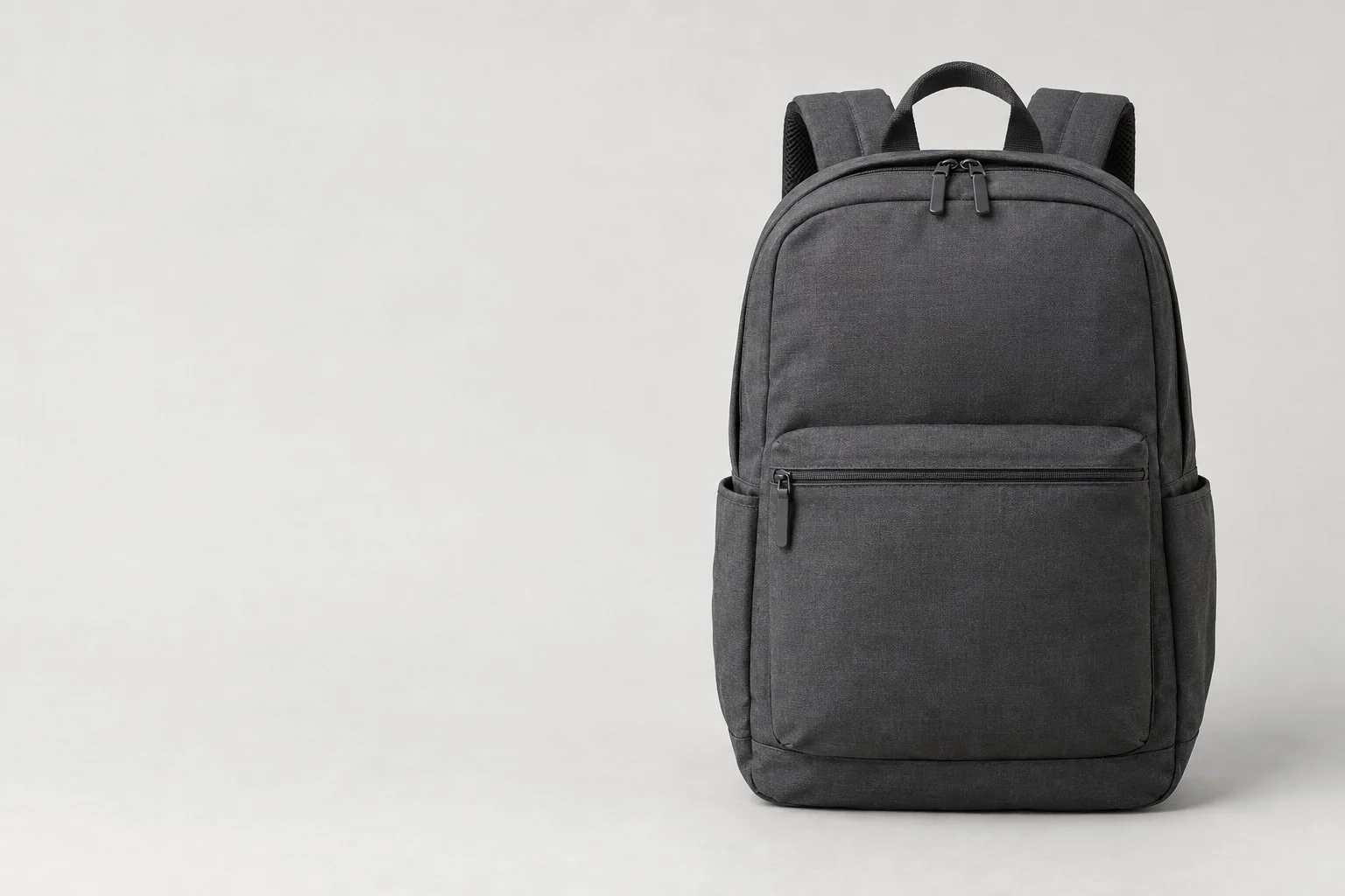 Sac à dos ordinateur gris foncé avec poche zippée frontale et poches latérales, sans annotations